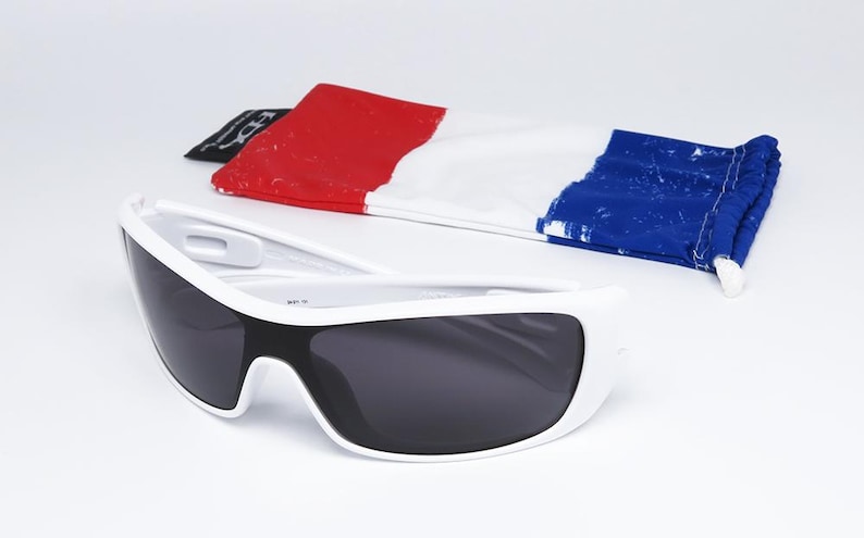 Op de afbeelding: Witte zonnebril met donkere glazen en een etui in de kleuren van de Franse vlag: rood, wit en blauw. De zonnebril heeft een sportief, modern design.