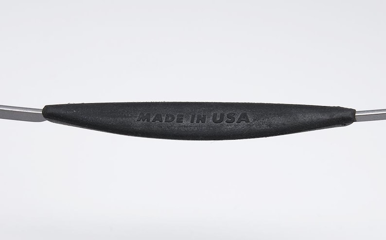 May include: Close-up of a black rubber handle with the text "MADE IN USA" embossed on it. The handle is attached to a metal object.