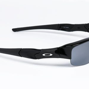K&ouml;nnte beinhalten: Schwarze Sonnenbrille mit grauen Gl&auml;sern. Die Sonnenbrille hat einen gl&auml;nzend schwarzen Rahmen und ein silbernes Logo an den B&uuml;geln. Die B&uuml;gel sind gebogen und erstrecken sich nach au&szlig;en. Die Gl&auml;ser sind dunkelgrau.