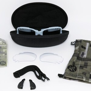 May include: A light blue sports sunglasses set with a black case, extra lenses, and accessories. The set includes a camouflage-patterned pouch and a clear lens set. The sunglasses are in a black case.
