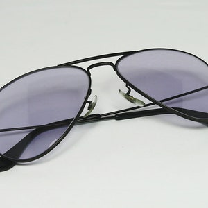 May include: Black aviator sunglasses with a dark purple lens.