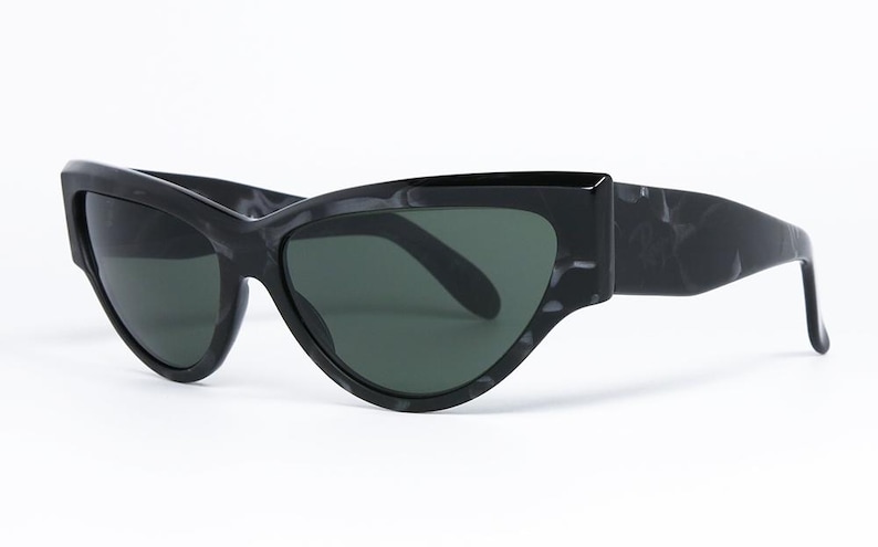 May include: Black cat-eye sunglasses with a marbled frame and dark lenses.