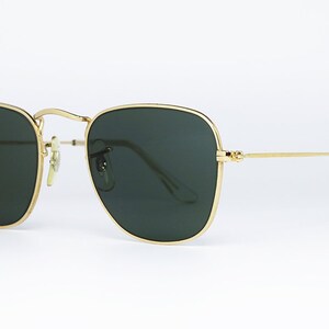 May include: Square sunglasses with gold frames and green lenses.