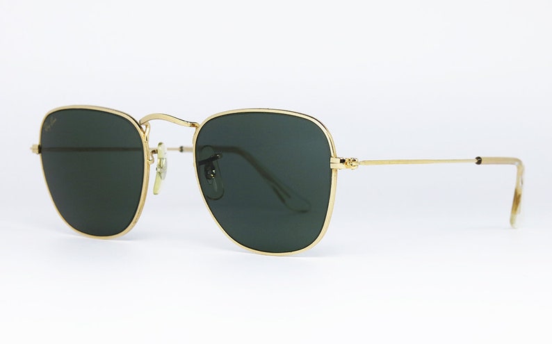 May include: Square sunglasses with gold frames and green lenses.