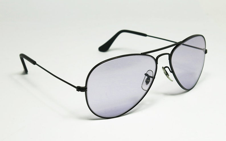 May include: Black aviator sunglasses with a light purple tint to the lenses.