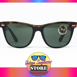 K&ouml;nnte beinhalten: Vintage Ray-Ban Sonnenbrille mit einem Schildpattgestell und gr&uuml;nen Gl&auml;sern. Die Sonnenbrille hat ein goldenes Ray-Ban Logo auf der rechten Linse.