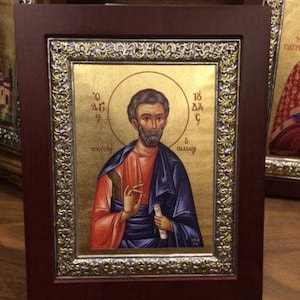May include: A framed religious icon with a gold background and a silver border. The icon depicts a man with a beard and a halo, wearing a red and blue robe. The text "Ο ΑΓΙΟΣ" and "ΘΕΟΔΩΡΟΣ" is visible on the icon.
