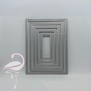 May include: A set of five silver metal rectangular frame dies for crafting. The dies are nested within each other, with the smallest die in the center and the largest die on the outside.