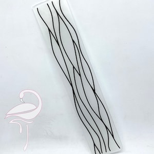 May include: A white rectangular glass panel with a black abstract design of wavy lines. The design resembles a pattern of branches or reeds.
