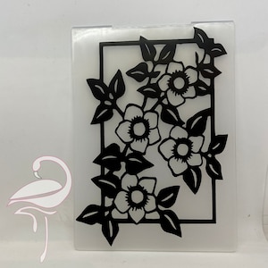Puede incluir: Diseño floral en blanco y negro recortado de una lámina de plástico transparente. El diseño presenta una vid con hojas y flores.