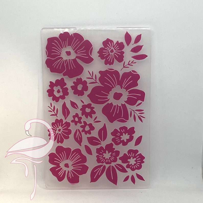 May include: A clear plastic sheet with a pink floral design. The design features various sizes and shapes of flowers, including large, medium, and small flowers.