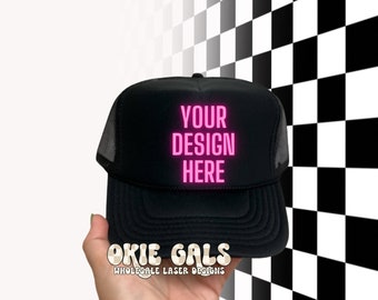 May include: Black trucker hat with a mesh back. The hat has a pink neon design that says "YOUR DESIGN HERE".
