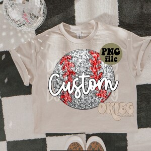 May include: A beige t-shirt with a glittery silver and red baseball graphic and the word "Custom" in white. The graphic has a PNG file label.