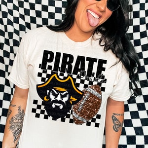 May include: White t-shirt with a black and white checkered pattern. The shirt has a black and gold pirate logo with a football and the text "Pirate Pride".
