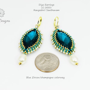 May include: Teal blue gemstone earrings with gold accents and white pearl drops. The earrings are shown next to a US quarter for size reference. Diya Earrings (c) 2021 Rangashrii Santhanam Blue Zircon/champagne colorway