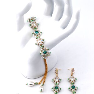 May include: A set of green and white beaded earrings and a bracelet with a gold chain. The earrings and bracelet feature green and white beads and a single large green gemstone in each piece. The text "Pop of Color Bracelet and Earrings (c)2022 Apple green/champagne colorway" is above the jewelry.