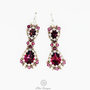 May include: A pair of dangle earrings with a teardrop-shaped purple and gold bead design. The earrings are made with small beads and crystals. The earrings are called "Ostara Earrings (c) 2021 Purple/nickel colorway" and are by "Shrii Designs Rangashrii Santhanam".