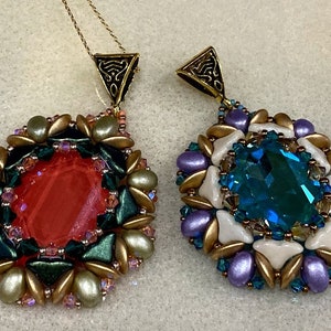 May include: Two beaded pendants with gold-tone metal bails. The pendant on the left has a red gemstone surrounded by green, gold, and clear beads. The pendant on the right has a blue gemstone surrounded by white, gold, and purple beads.