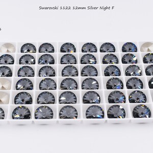 May include: A white tray with 36 round, dark gray Swarovski 1122 12mm Silver Night F crystals.
