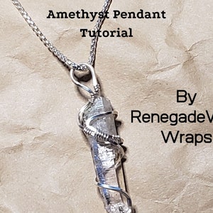 Op de afbeelding: Een zilveren ketting met een zilverdraad gewikkelde amethist hanger. De hanger is een lange, heldere kristal met een zilverdraad eromheen gewikkeld. De tekst "Amethyst Pendant Tutorial By RenegadeWire Wraps" is zichtbaar in de afbeelding.