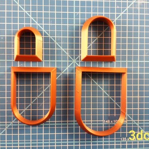 Puede incluir: Cuatro cortadores de galletas de pl&aacute;stico naranja con forma de ventanas arqueadas. Dos son formas completas de ventanas y dos son solo los marcos de las ventanas. Los cortadores est&aacute;n sobre una superficie de cuadr&iacute;cula azul. El texto "3dcutterlab" est&aacute; en la esquina inferior derecha.