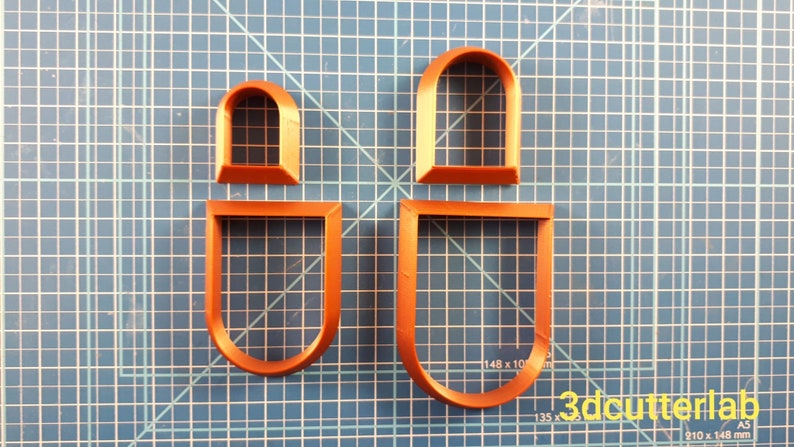 Puede incluir: Cuatro cortadores de galletas de pl&aacute;stico naranja con forma de ventanas arqueadas. Dos son formas completas de ventanas y dos son solo los marcos de las ventanas. Los cortadores est&aacute;n sobre una superficie de cuadr&iacute;cula azul. El texto "3dcutterlab" est&aacute; en la esquina inferior derecha.