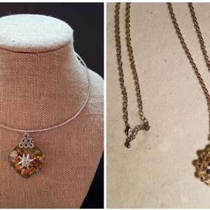 Peut inclure: Deux colliers, l'un avec une chaîne dorée et l'autre avec une chaîne argentée. Les deux colliers présentent un pendentif avec un motif en étoile jaune et brun.