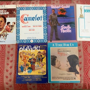 May include: A collection of six vintage vinyl record album covers. The covers feature a variety of musical genres, including musicals, pop, and classical. The covers are in good condition and have a retro look.