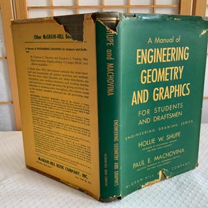May include: A vintage textbook titled "A Manual of Engineering Geometry and Graphics" with a green cover and gold lettering. The book is part of the Engineering Drawing Series and is for students and draftsmen. The book's spine reads "SHUPE and MACHOVINA".