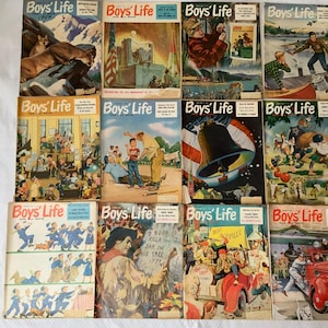 May include: A collection of vintage "Boys' Life" magazines. The covers feature colorful illustrations of outdoor scenes, historical events, and various activities. The magazines are stacked on a white surface.
