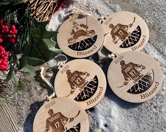 May include: Five wooden hockey-themed ornaments with player silhouettes and the word "Blizzard". Each ornament features a different player number and name, along with the year "2022-2023". The ornaments are round with a light wood finish.