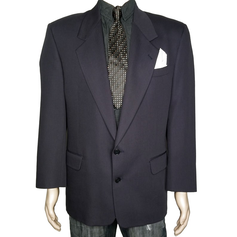 May include: A dark blue blazer with a single button closure and a pocket square. The blazer has a notched lapel and a plain front.