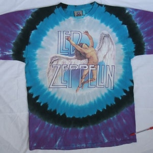 May include: Tie-dye t-shirt with a circular pattern in shades of blue, purple, and black. The shirt features the band name "LED ZEPPELIN" in white block letters, along with an image of a winged figure.