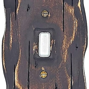 Peut inclure: Un cache-interrupteur en bois rustique avec une finition brune vieillie et des accents dorés. La plaque d'interrupteur a une ouverture rectangulaire pour un interrupteur standard.
