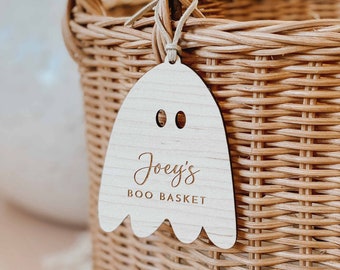 May include: A wooden ghost-shaped tag with the text "Joey's Boo Basket" hanging from a wicker basket.