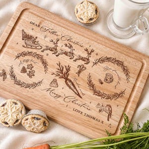 May include: A rectangular wooden serving board engraved with a Christmas scene featuring a sleigh, reindeer, a carrot, wreaths, and text reading Dear Father Christmas, A tasty treat, Your favorite snack, Merry Christmas, and LOVE THOMAS X.