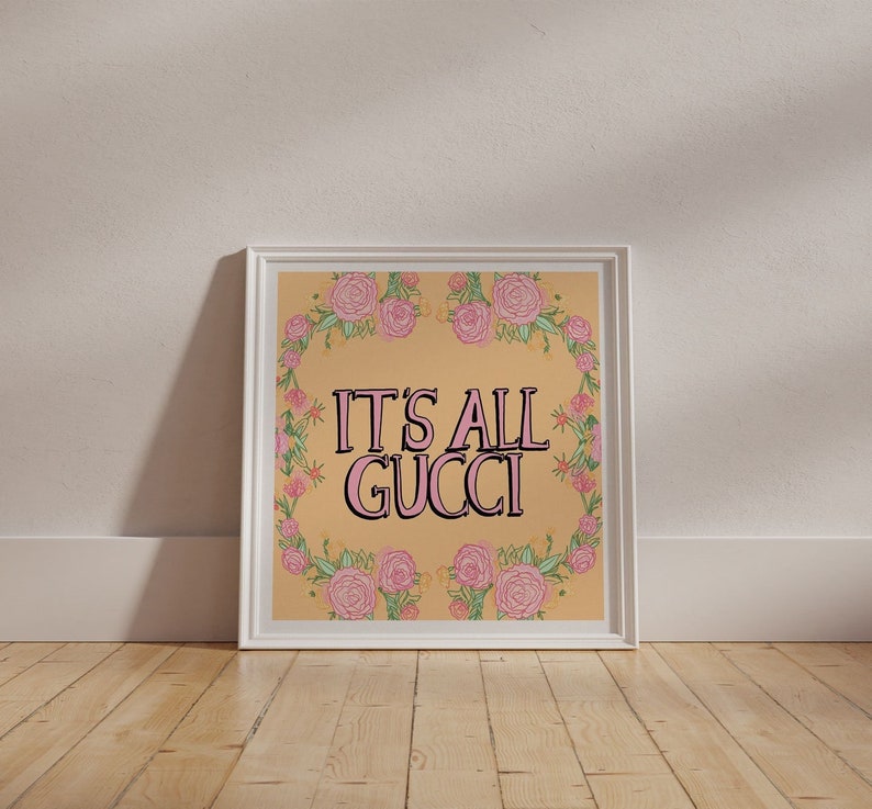 "It's All Gucci" mantra, a positive floral & typography wall art. 
Vibrant yellow contrasting against pink lettering, with pink and green floral details around the border, creating a bold and colourful feel-good poster.