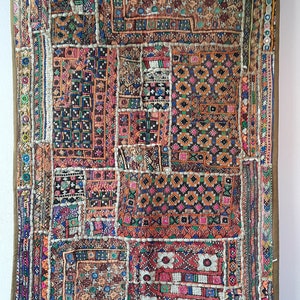 Peut inclure: Textile rectangulaire multicolore avec un motif patchwork. Le textile présente une variété de motifs géométriques et de textures, notamment des carrés, des rectangles et des broderies complexes. La palette de couleurs comprend des nuances de rouge, d'orange, de bleu et de vert.