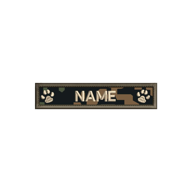 May include: A camouflage-patterned dog ID tag with a white border and the word "NAME" in white text. The tag has a paw print on each end.