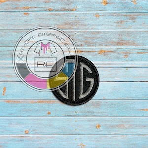 May include: Two embroidered patches on a blue wood background. The larger patch is black with white lettering that says "BIG". The smaller patch is multi-colored with the text "X RIVERS EMBROIDERY" and "RE".