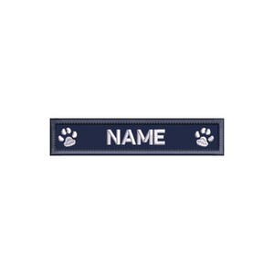 May include: A navy blue rectangular dog tag with white paw prints on either side and the word "NAME" in white text.