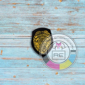 May include: A gold and black embroidered patch with the text "Sergeant Mullen State Police" and a stylized eagle design. The patch is on a blue wooden background.