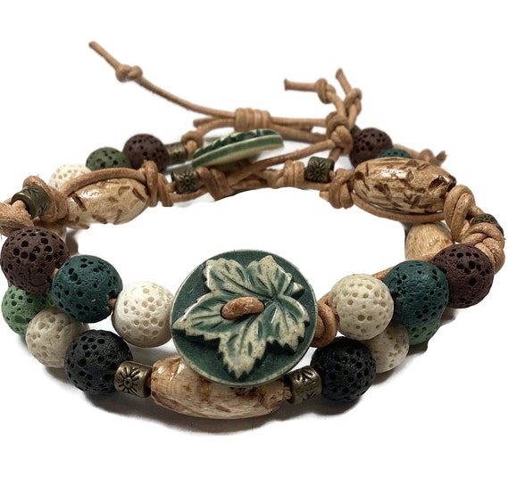 Leather stack bracelets, lava beads, decorative buttons, leather cord, one with adjustable knot, other with button and loop, green and tan