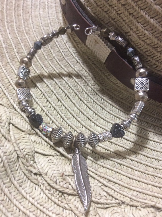 Silver tone beaded bracelet on memory wire, feather charm