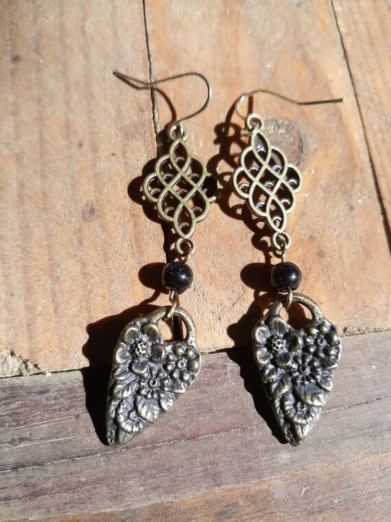 Black and antique brass earrings with textured heart and filigree drop.