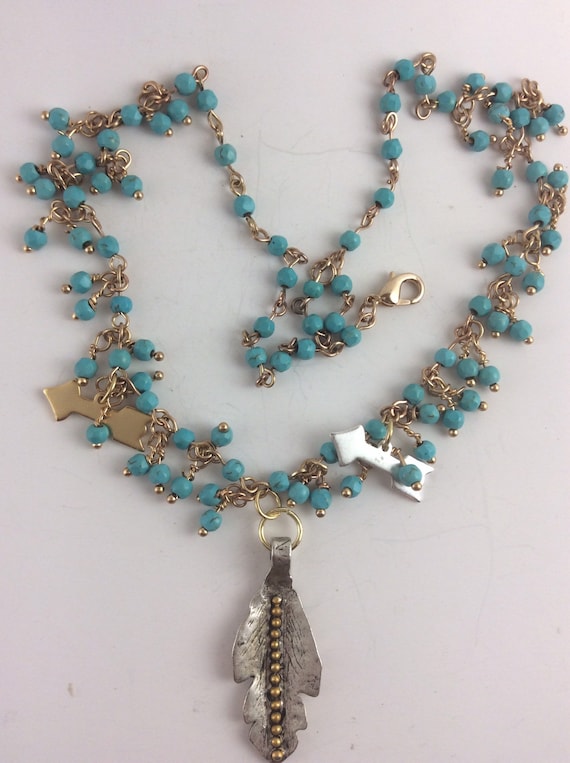 Southwest style necklace with gold tone and silver tone charms/turquoise color beads