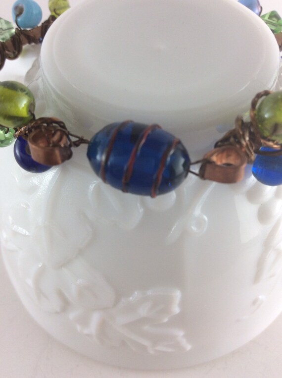 Copper bangle with blue and green lamp work beads