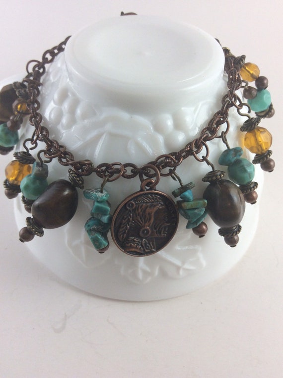 Copper charm bracelet with turquoise, tiger’s eye and honey color beads, copper chain, lobster claw closure.