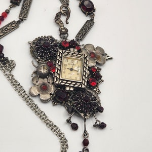 Assemblage necklace is a collage using a vintage watch and vintage pieces to create a steampunk style piece, red and silver necklace
