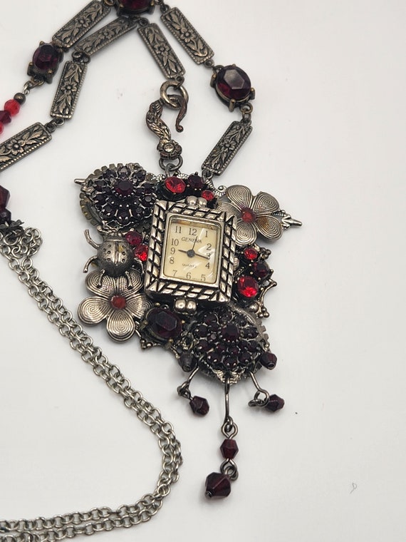 Assemblage necklace is a collage using a vintage watch and vintage pieces to create a steampunk style piece, red and silver necklace
